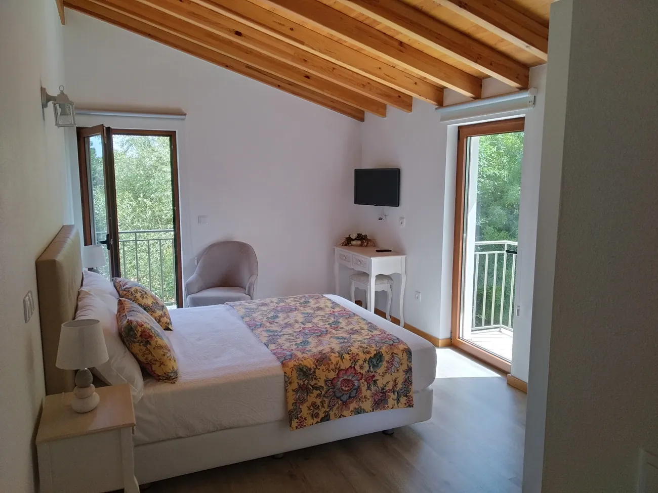 Quarto Superior do Moinho Real, com cama de casal e detalhes em madeira